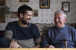 © Jovana Milanko/Stocksy - Grandpa and his grandson sitting at the table talking and laughing
