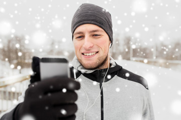 Sticker - happy man with earphones and smartphone in winter