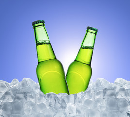 Wall Mural - Cold bottle of beer with drops in ice cubes over blue background