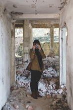 Young Woman Urban Exploring An Old Building With Her Camera
