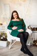 © Nestyda - Beautiful pregnant girl with Big belly on a Christmas, having a rest on Christmas holidays before the new year. the concept of a new life