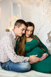 © Nestyda - Beautiful pregnant couple in love, having a rest on Christmas holidays before the new year. Big pregnant belly