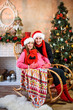 © Nestyda - Beautiful pregnant couple in love on the background of a Christmas tree, having a rest on Christmas holidays before the new year. Big pregnant belly