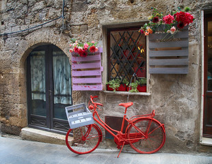 Sticker - Red bike in a traditional Italian medieval town, Tuscany, Italy.