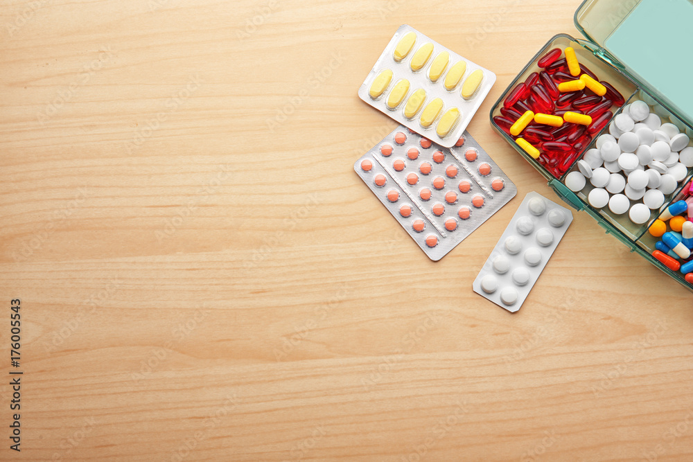 Composition with different pills on wooden background