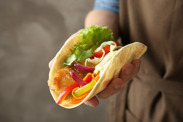 Wall Mural - Woman holding delicious fish taco, closeup