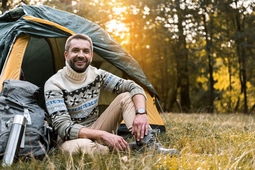 Wall Mural - Joyful male tourist resting in the forest