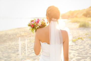 Wall Mural - Beautiful bride with wedding bouquet on beach