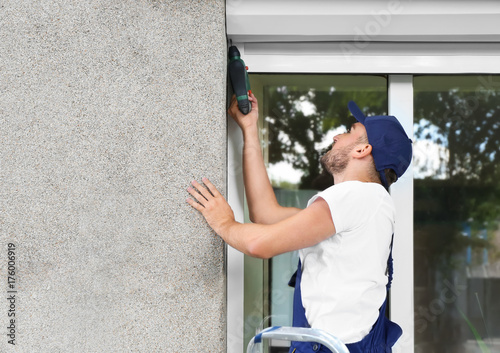 Cuadros en Lienzo Man installing roller shutter on window