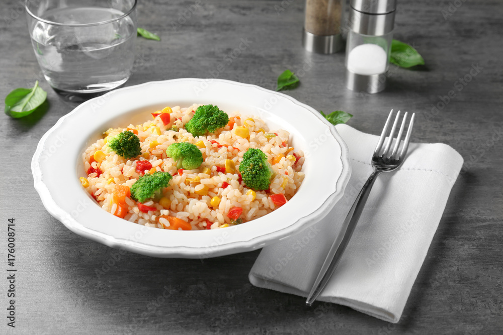 Plate with rice pilaf and broccoli on table