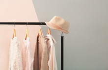 Apricot And Beige Clothes On Hangers Against Trendy Color Background