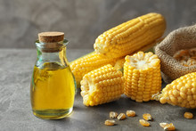 Glass Jar With Corn Oil On Grey Background