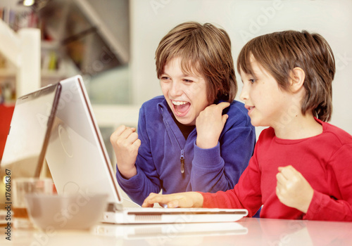 Zdjęcie XXL Bracia w domu w stylu loftu, bawiący się w laptopach, poważni, śmiejący się, całkowicie zszokowani i zabawni