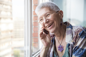 Smiling senior elderly lady having a pleasant conversation over her phone