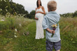 © Goodness Grace Photography/Stocksy - Boy hiding bouquet of wildflowers behind his back for his pregnant mother