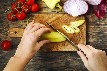 Sticker - Close-up of woman hands cutting vegetables on the board, top view