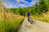 Fototapeta Lawenda - Cycling, mountain bikeing woman on cycle trail in autumn forest. Mountain biking in autumn landscape forest. Woman cycling MTB flow uphill trail.