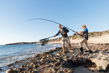 Wall Mural - Senior man fishing with his grandson