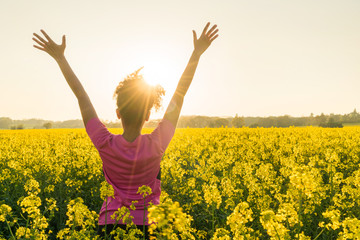 female woman athlete runner celebrating in yellow flowers