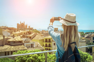 Woman tourist with her phone camera in hands shooting in Palma d