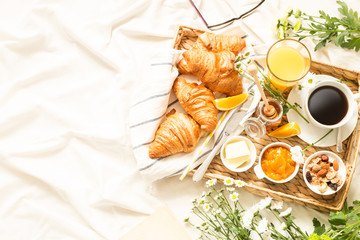 continental breakfast on white bed sheets - flat lay