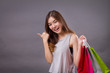 woman shopper with shopping bag pointing up sideway