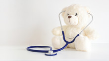 Teddy Bear With A Stethoscope. Pediatrician Healthcare For Children. Empty Copy Space For Editor's Text.