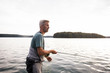 © Gonzales Photo - A man in waders is fly fishing from a boat on lake.
