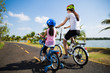 © torwaiphoto - Mother and daughter were cycling at the park in the morning.