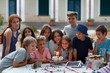 © Miquel Llonch/Stocksy - Group of children gathered around a birthday cake