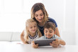 © Louis-Paul Photo - Adorable brother and sister young child using tablet with mother