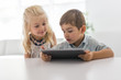 © Louis-Paul Photo - Adorable brother and sister young child using tablet
