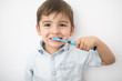 © Louis-Paul Photo - smiley boy cleans a teeth isolated on grey background