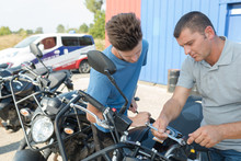 Men Checking Motorbike At An International Automobile Salon
