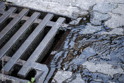 Fotografía Wasser / Regenwasser fliesst in Kanal Deckel