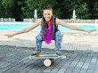 Girl on oval wooden deck for balance board. Plastic roller for balance board. Rocker-roller boards.