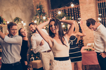 Canvas Print - Celebrating newyear. Gorgeous brunette elegant charming lady with raised hands, in beige outfit, group of festive youth on fancy feast, classy outfits, all night, indoors event