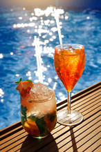 A Glass With An Orange Cocktail Near The Pool