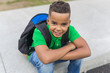 © Louis-Photo - cheerful african american primary school boy with backpack