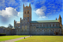 Church Cathedral Against A Blue Cloudy Sky And A Lush Green Grass Freground