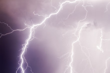 Thunder Storm Lightning Strike On The Dark Purple Cloudy Sky Background At Night