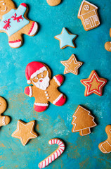 Wall Mural -  Ginger men with colored glaze on a turquoise background .. Gingerbread. Christmas cookies. Ginger man in a colored sweater. Gingerbread Santa