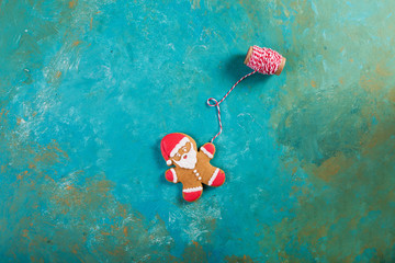 Wall Mural -  Ginger men with colored glaze on a turquoise background .. Gingerbread. Christmas cookies. Ginger man in a colored sweater. Gingerbread Santa