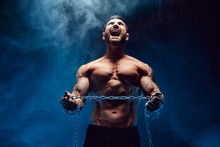 Shirtless Bodybuilder Man Standing With Chain And Screaming. Try To Break The Chain