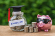 glass jar with full of coins and graduates hat label with Piggybank and stack of coins as Education, education or savings concept