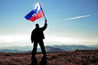 Successful silhouette man winner waving Haiti flag on top of the mountain peak