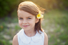 Portrait Of A Smiling Girl With A Flower In Her Hair
