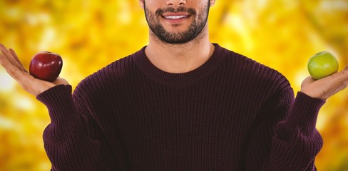 Wall Mural - Composite image of portrait of young man showing apples