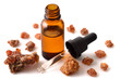 Myrrh essential oil in the amber bottle isolated on white