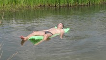 Resting The Man In The Hot Summer Day Swimming In The River On The Mattress.